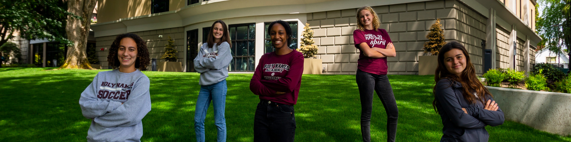 teen girls standing on grass outside a building