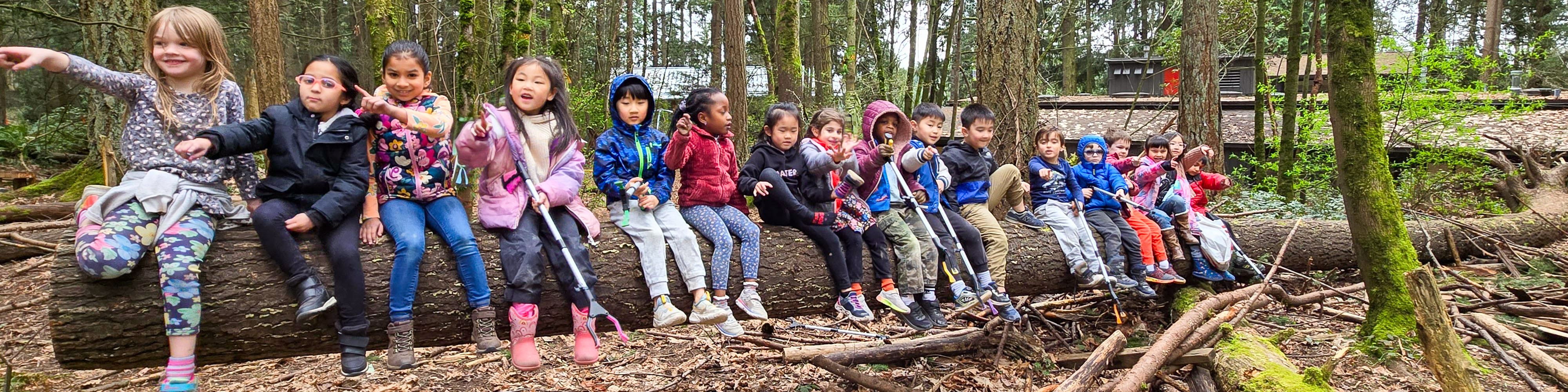 children sitting on log pointing