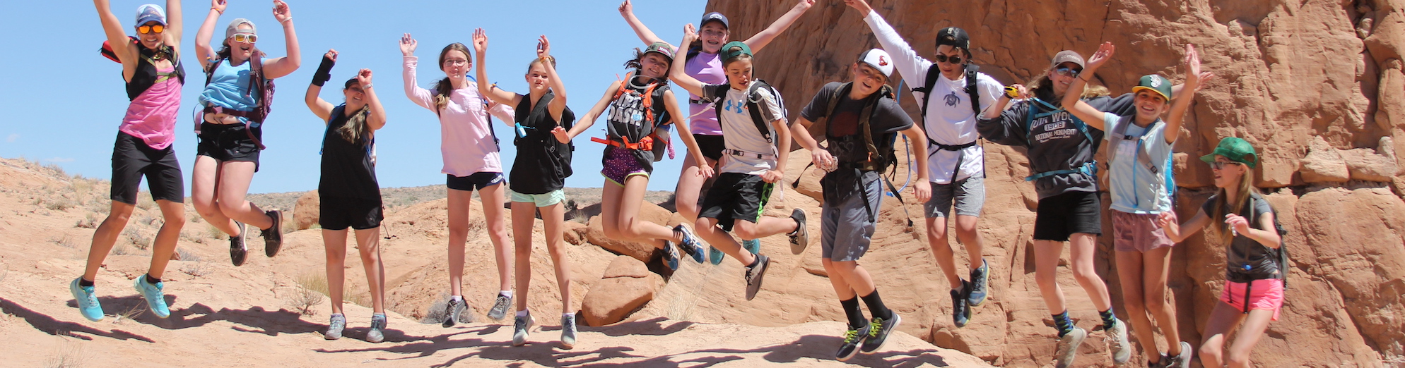 students jumping among red rocks