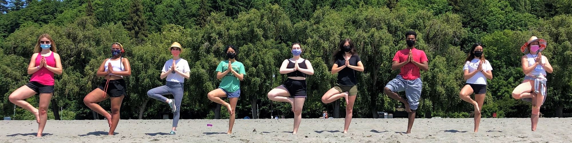 masked students in a line doing yoga pose
