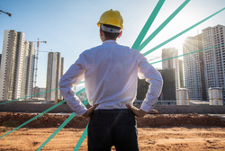 Engineer looking at horizon of buildings