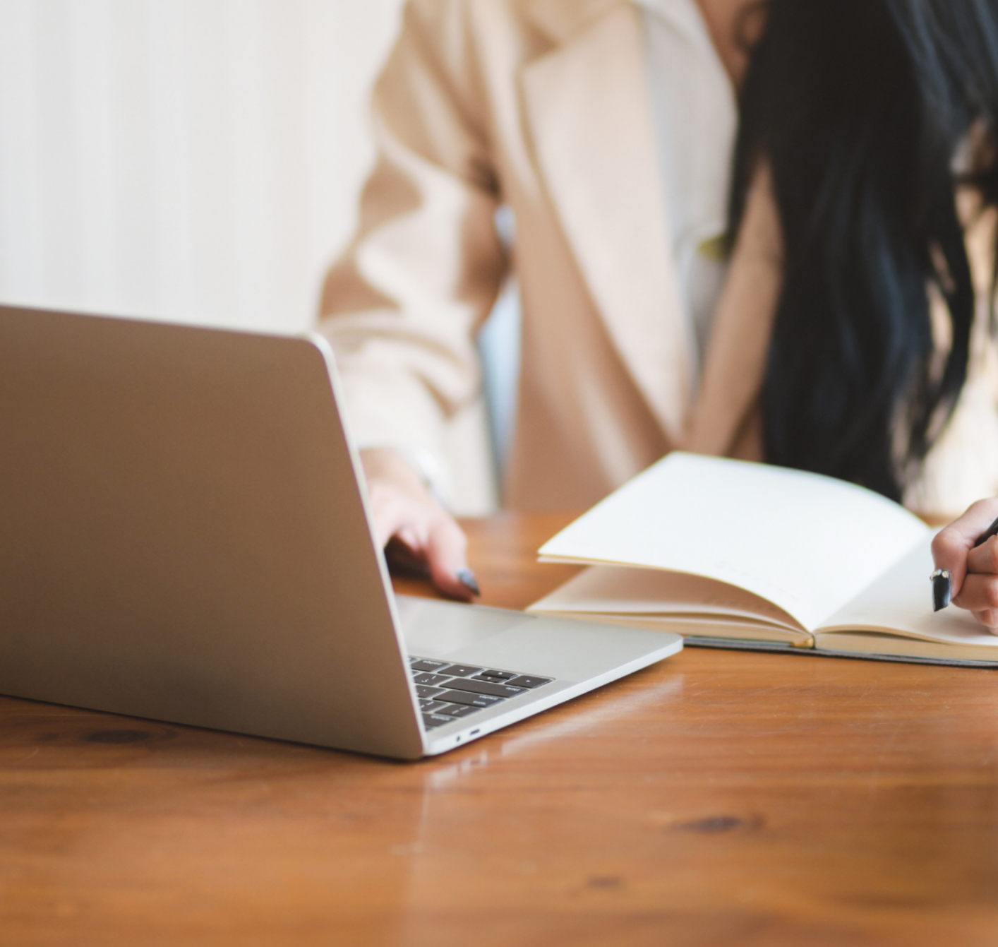 Image of laptop and person taking notes