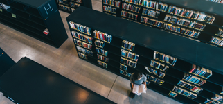 Photo of library shelves from above including visitor