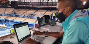 Photo of Nzumbe Nyanduga, Games Analytics Manager, checking the output from data capture sensors at the Gymnastics venue during a training event.