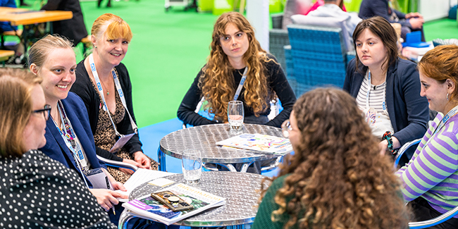 Image of young professionals at a conference table discussing ideas