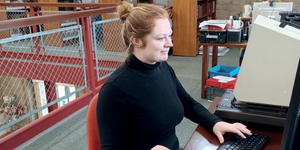 Photo of member of staff cataloguing a book