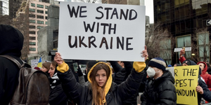 Protestor with banner saying We stand with Ukraine