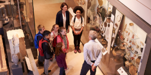 Photograph of children being guided around of a museum collection