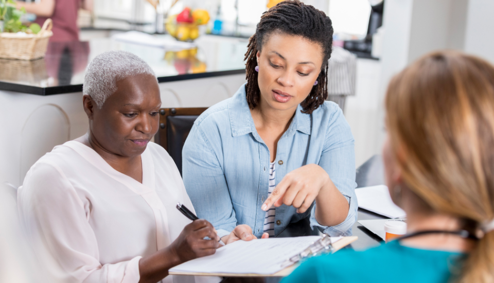 a group of doctors places their hands together in the center representing unity of purpose