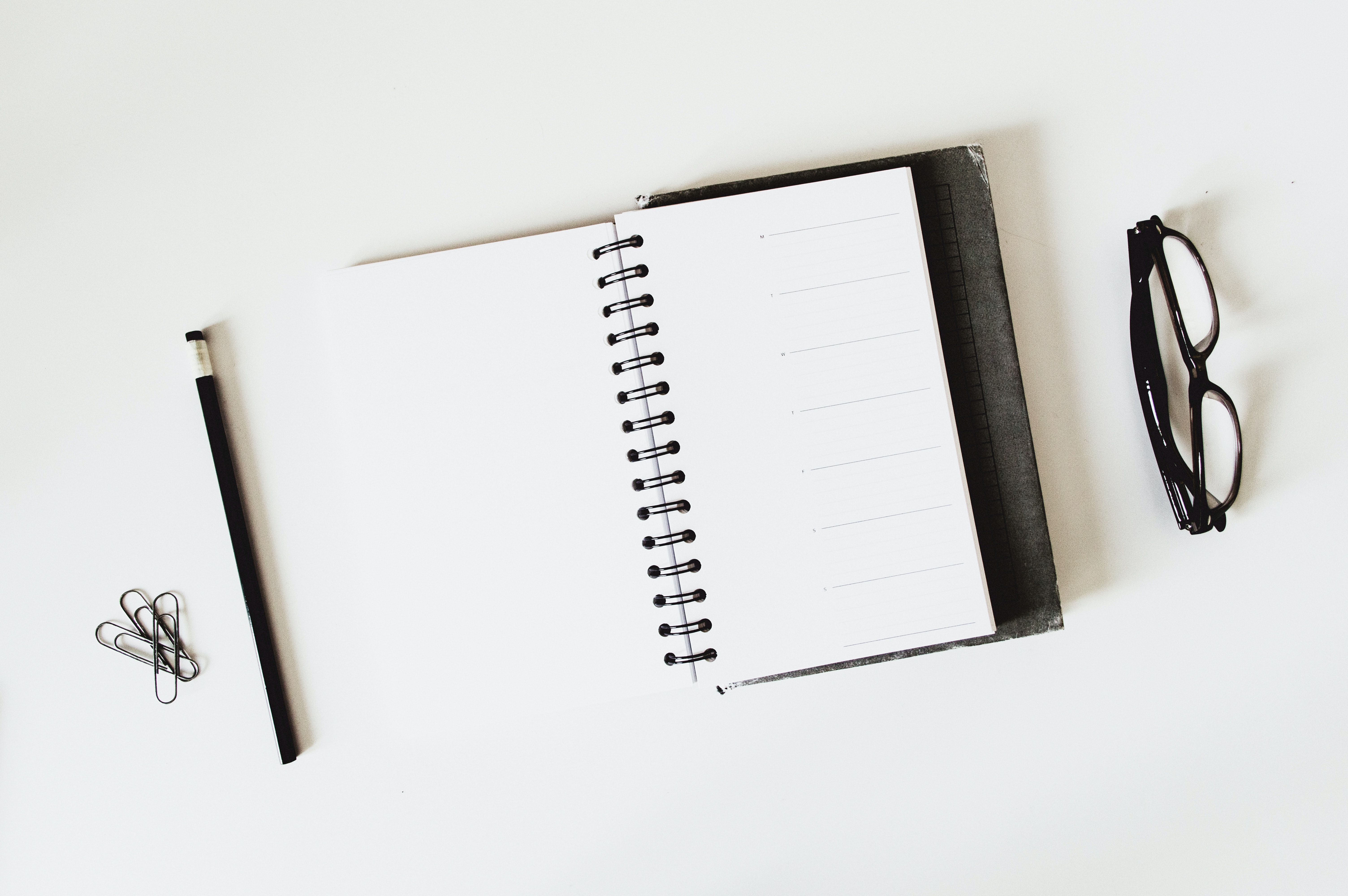 glasses, notebook and pen on table