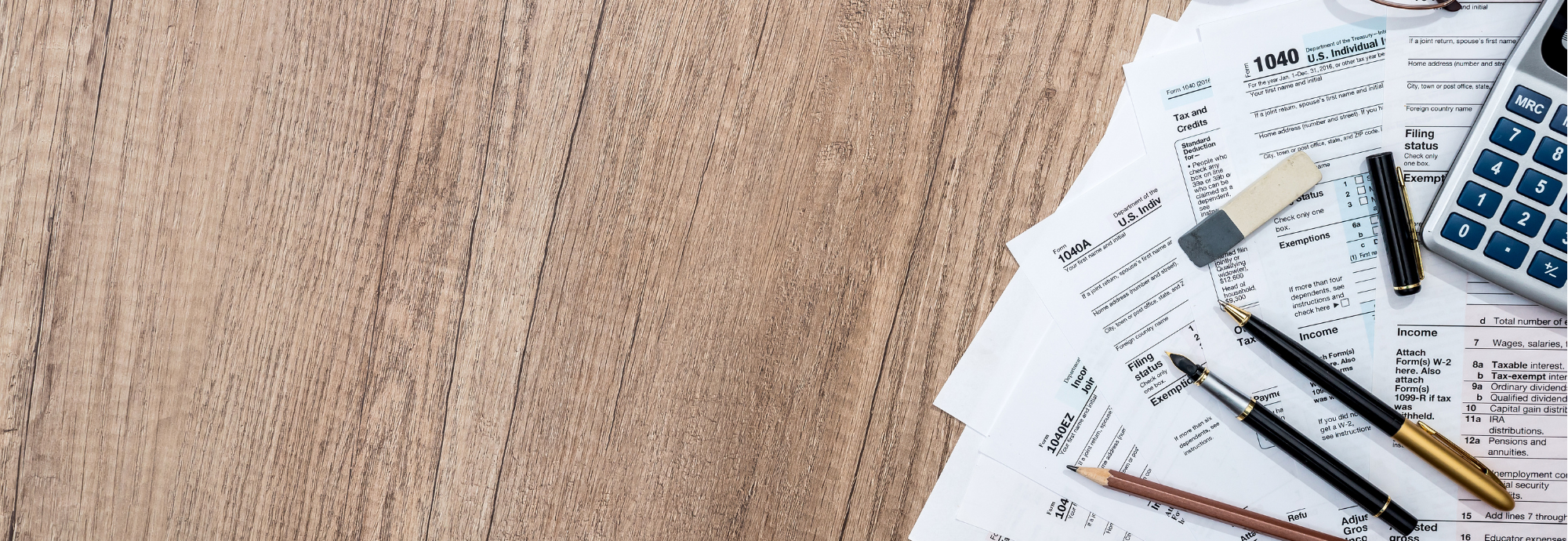 tax documents spread out on a table with pens and a calculator