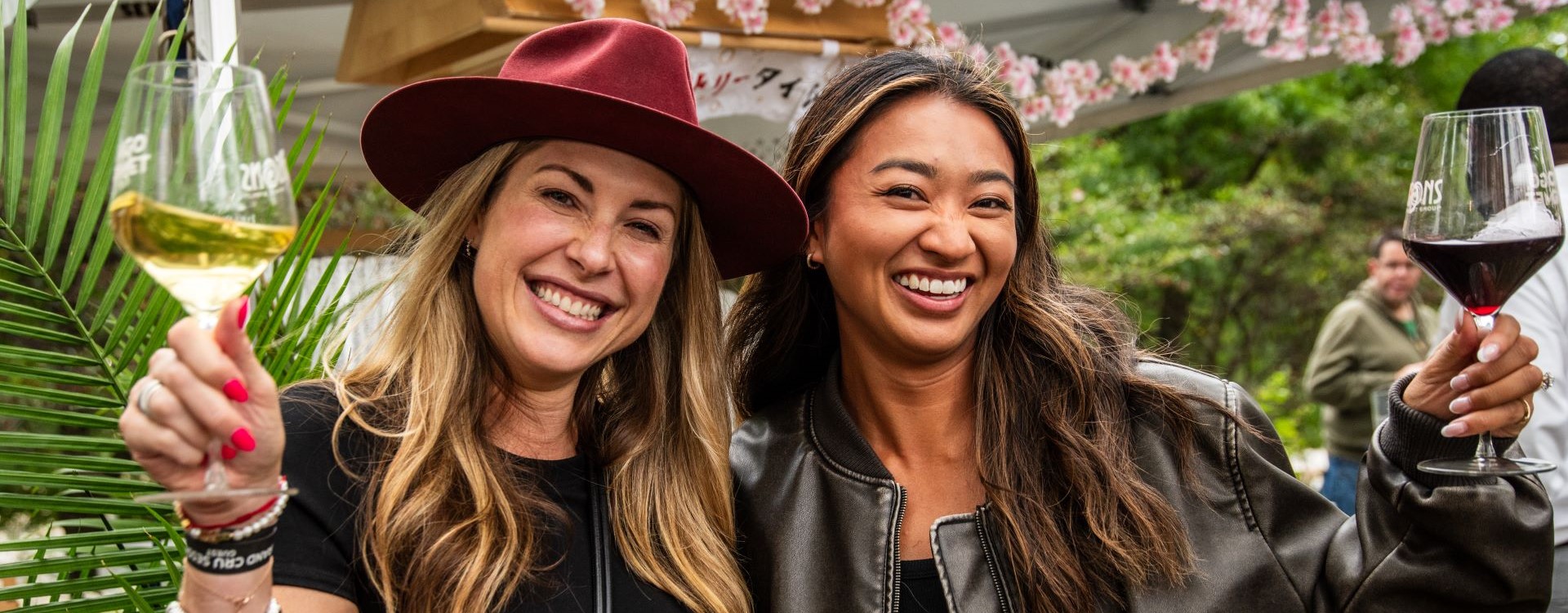 Two women holding up glasses at Grand Cru