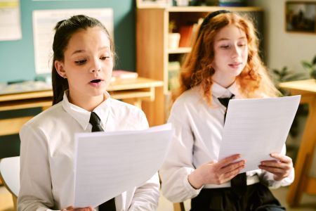 Oracy - two students speak aloud from sheets of paper
