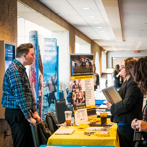 Student talking with a university representative at a conference.