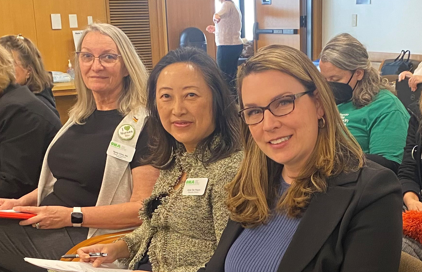 Tamie Cline, Anne Tan Piazza, and Dr. Jennifer Mensik Kennedy smile while sitting at hearings