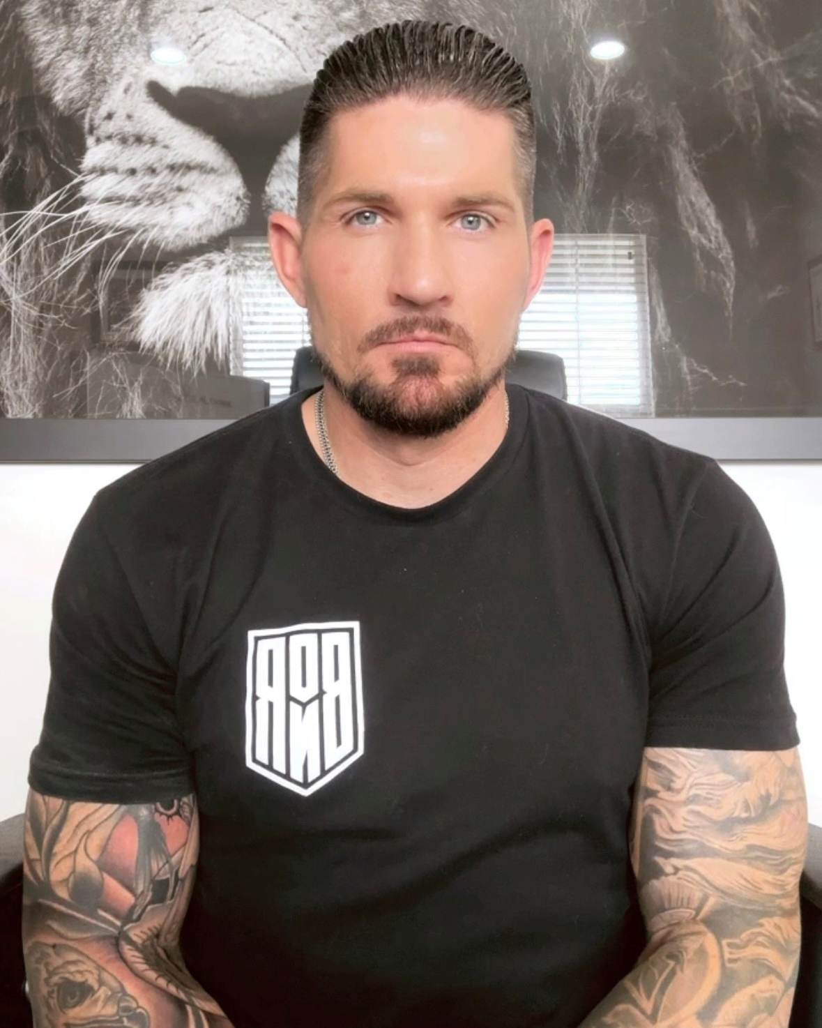 Photo of Shad Stoker standing before a gray wall from the waist up