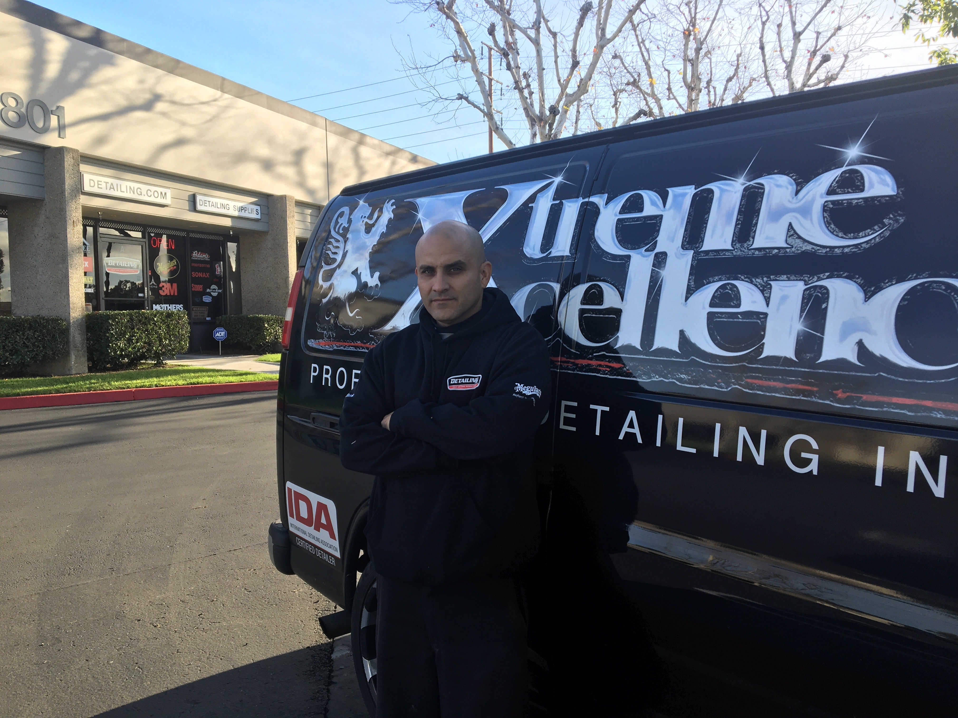 Photo outside of Rigo leaning against a Detailing Supply Co van.