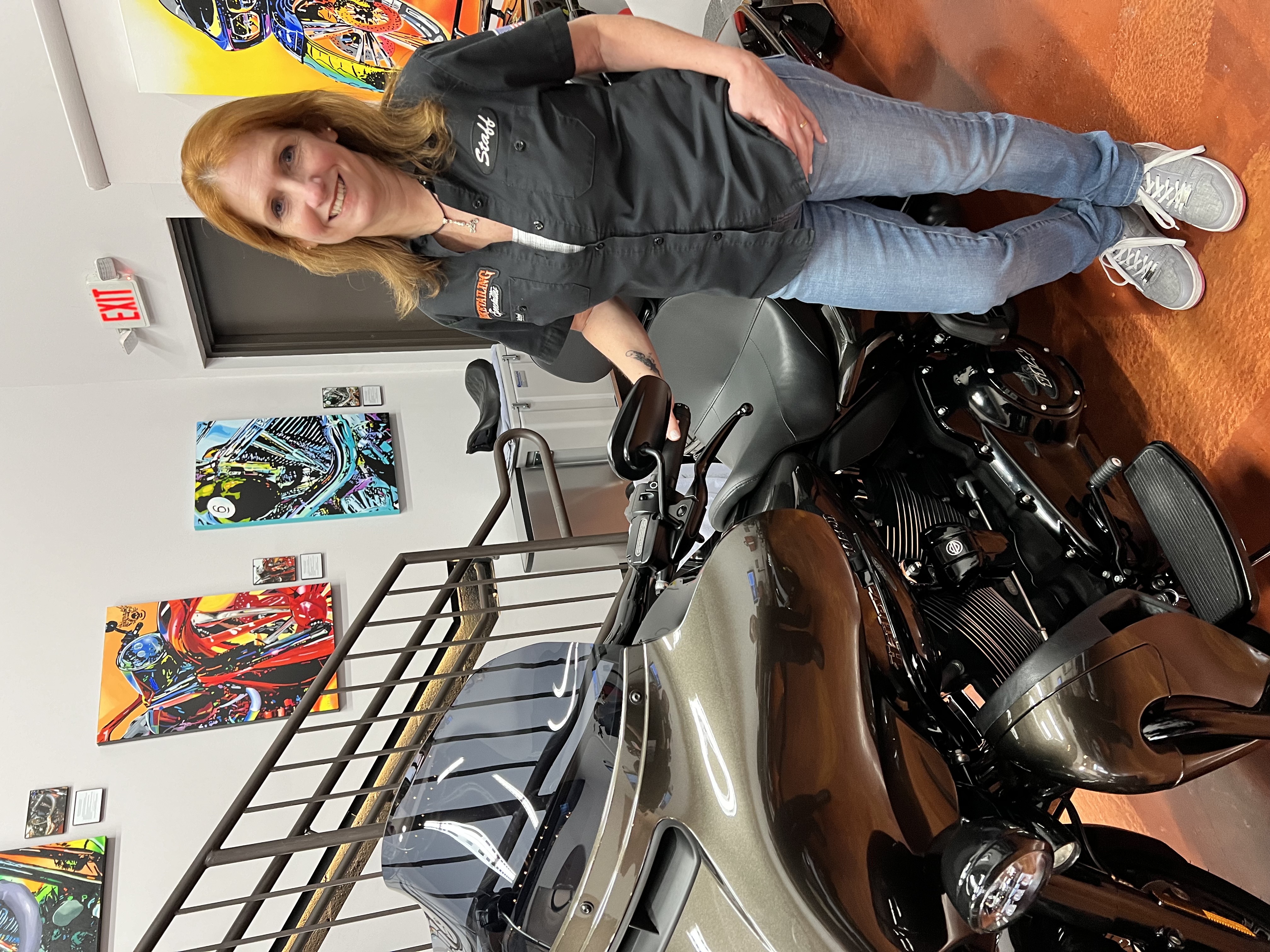 Julie standing in her shop next to a motorcycle