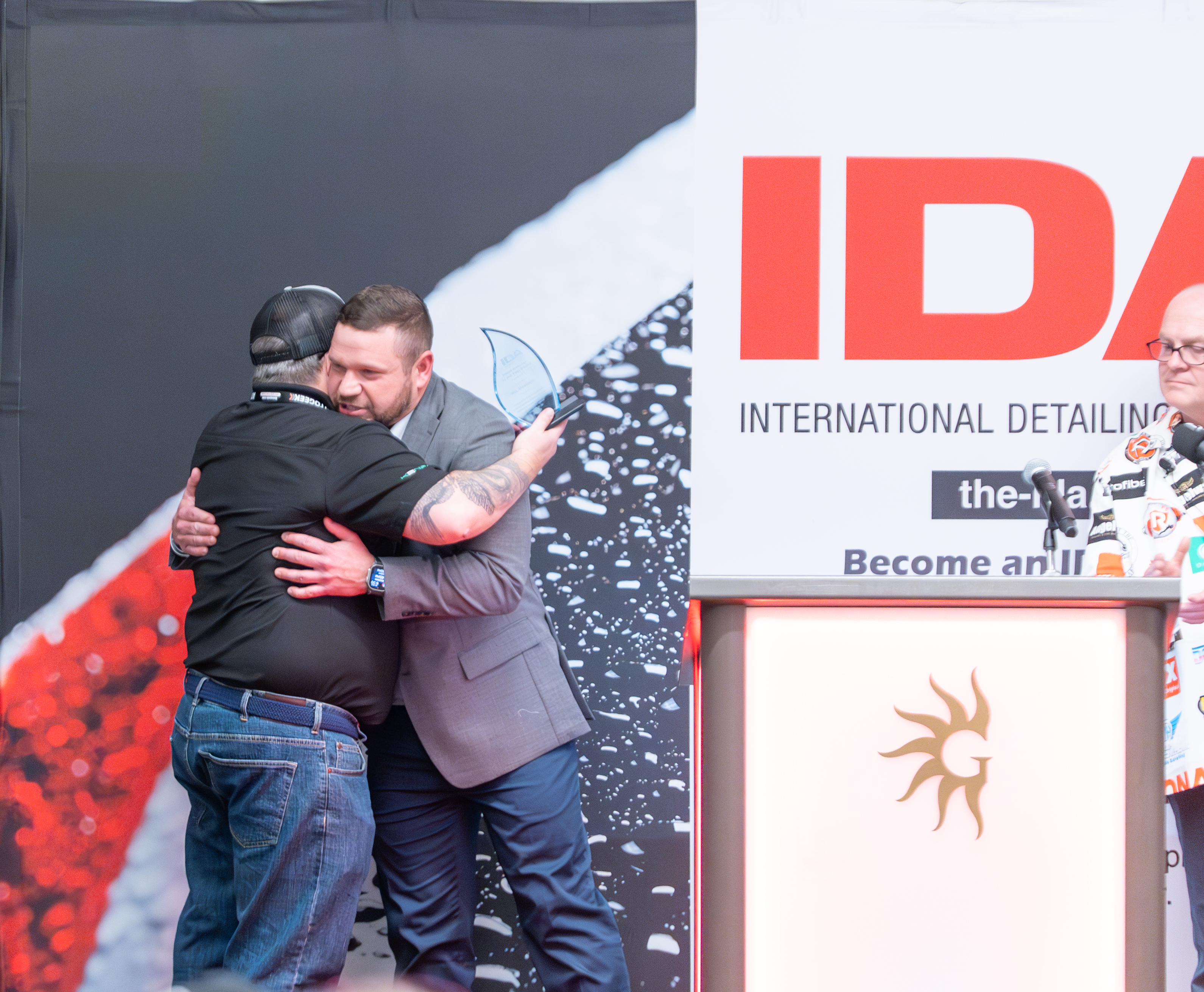 Joel hugging Barry on stage as he accepts his award