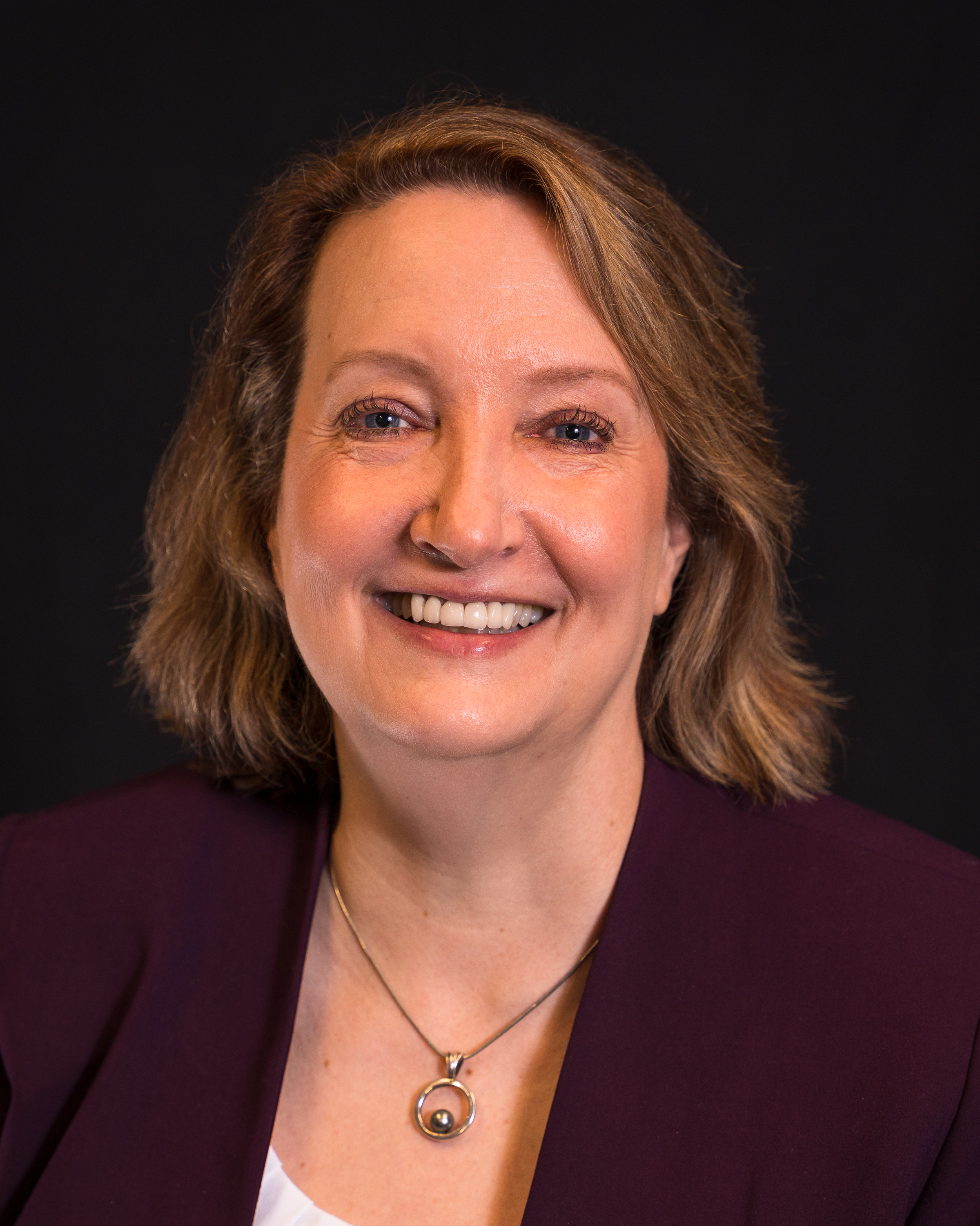 A person smiling for the camera Description automatically generated with medium confidence